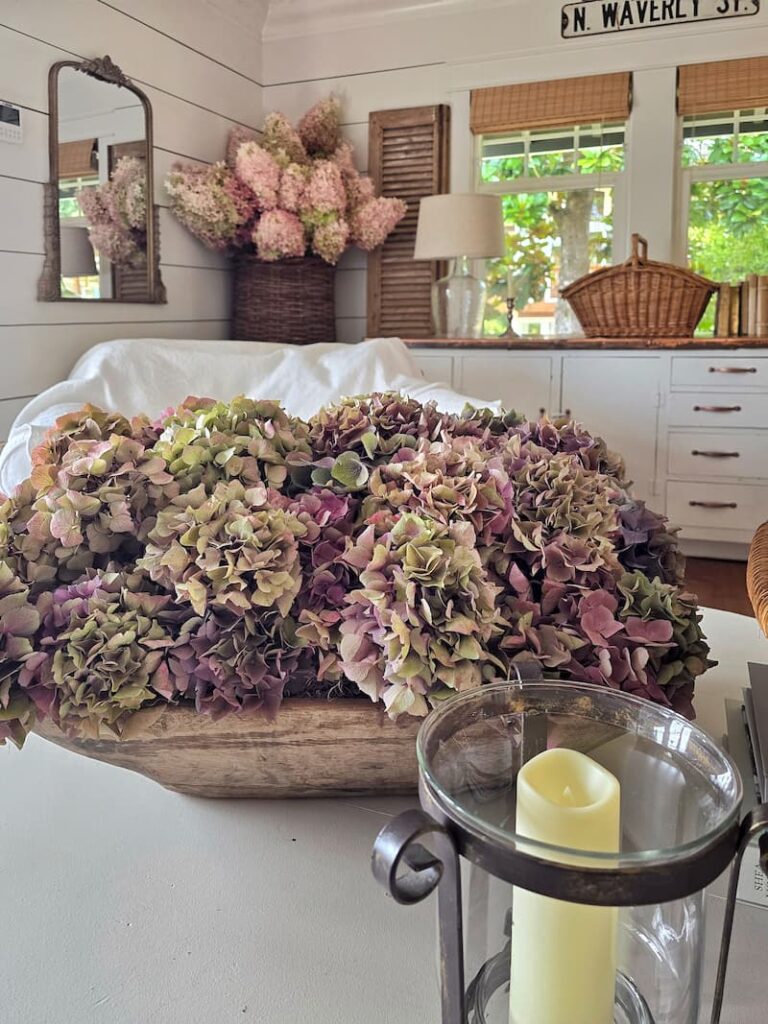 Vintage dough bowl filled with dried mophead hydrangeas as a fall cottage decor arrangement