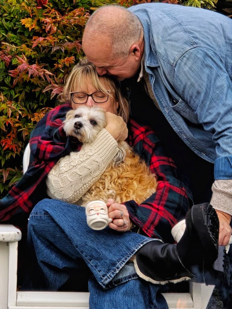 Couple and their dog posing outdoors for a Christmas magazine shoot