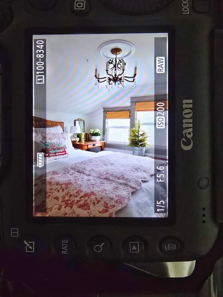 Guest bedroom decorated with moss and Christmas greenery seen through a camera screen