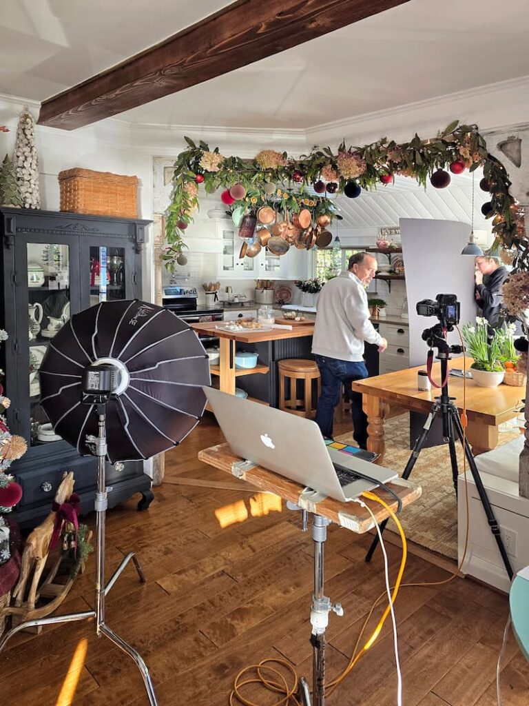 Photographer setting up a shot during a magazine Christmas photo shoot in a beach cottage