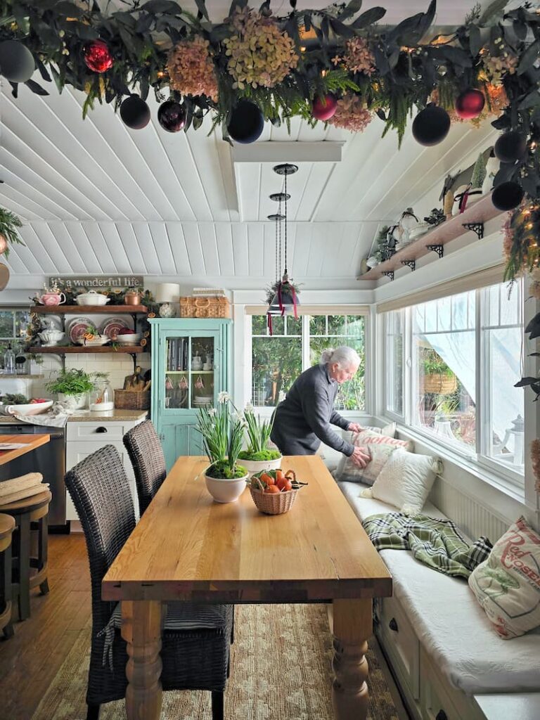 Stylist decorating a kitchen window seat for a Christmas magazine shoot